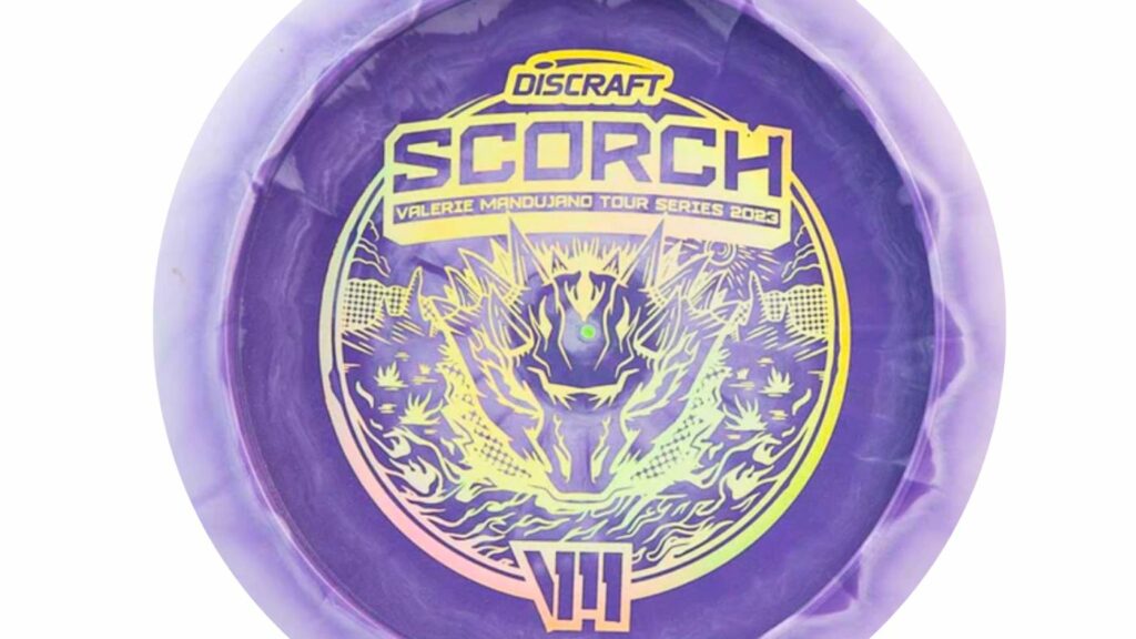 A Discraft Scorch disc from the Valerie Mandujano Tour Series 2023. The disc is color Purple with Holographic stamp and made of ESP plastic. 

Text from top to bottom 
Discraft 
Scorch
Valerie Mandujano Tour Series 2023
V11