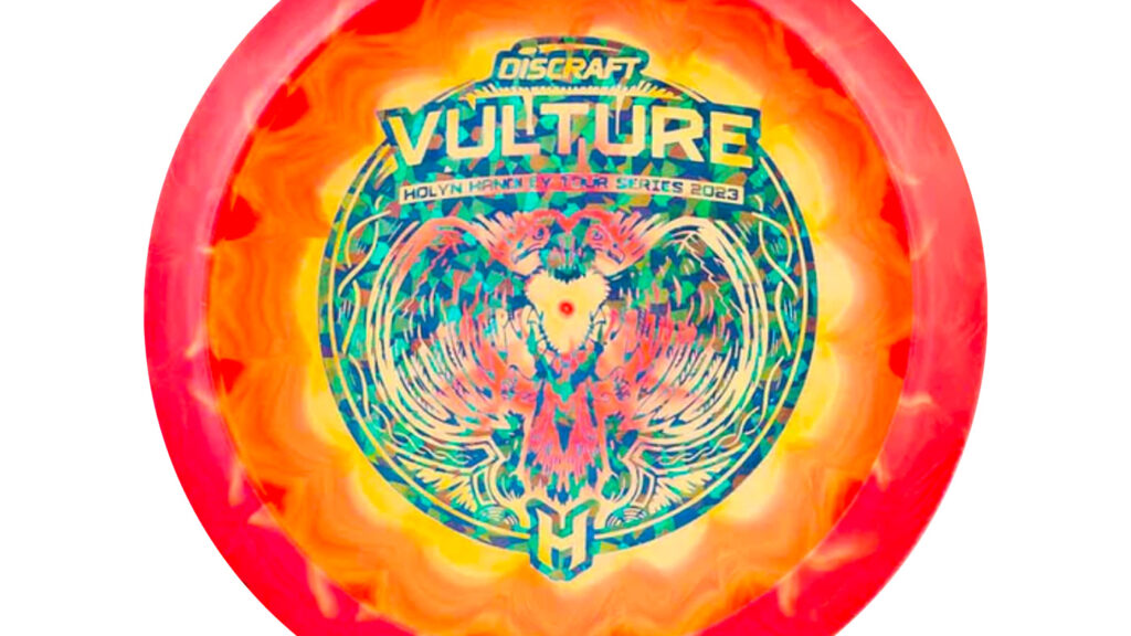 A Discraft ESP Vulture (Holyn Handley Tour Series 2023) with Hot Pink/Yellow color w/Blue Shatter (Metallic) Stamp 

The image on the disc features a circular design with a two-headed vulture at its center